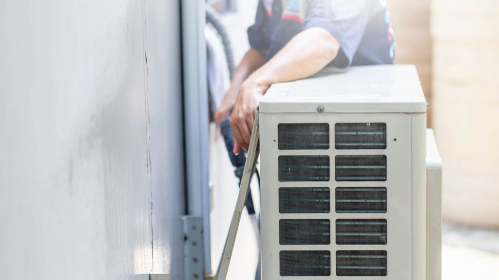 A person fixing an HVAC unit