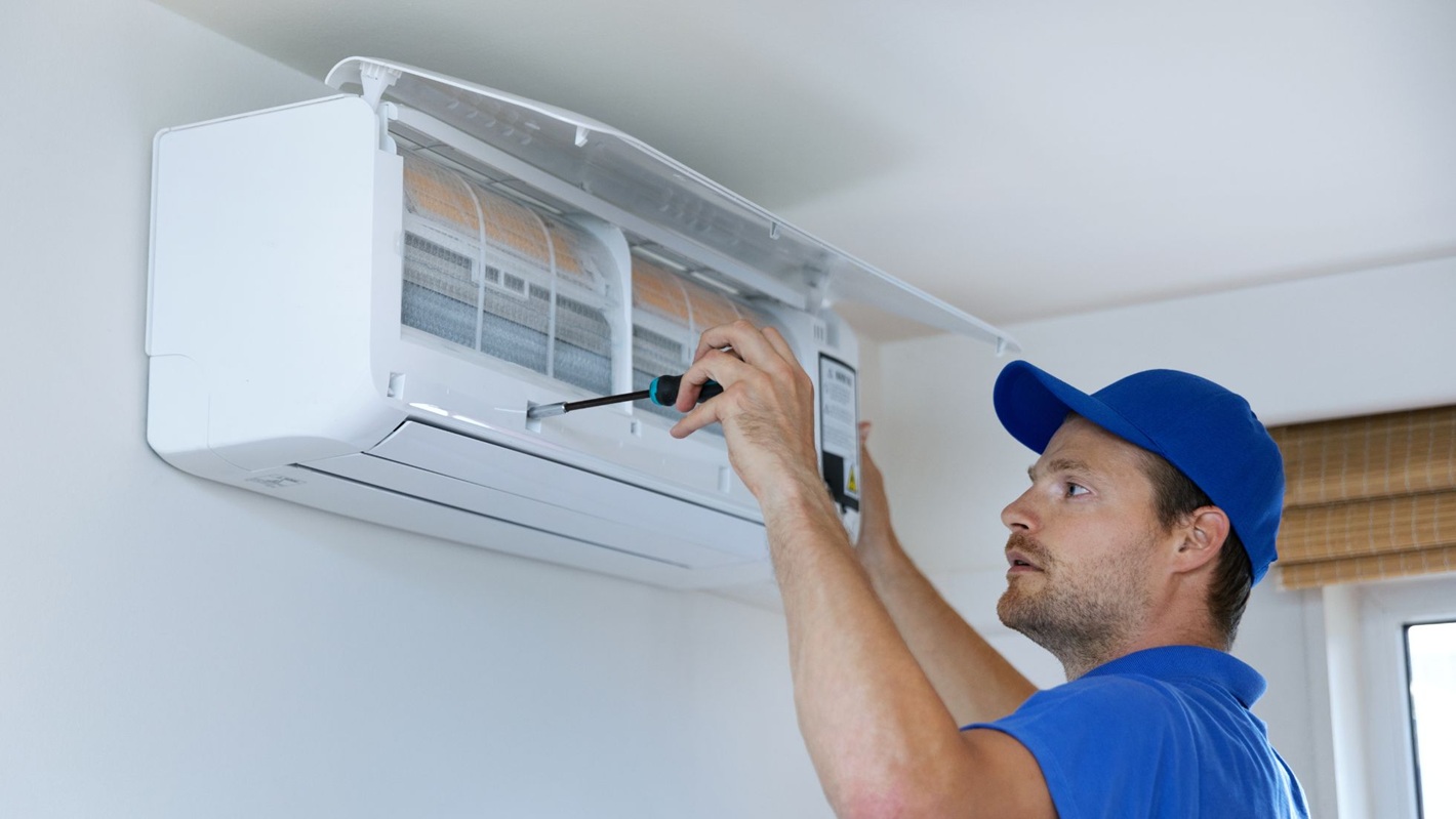 A professional fixing an AC unit